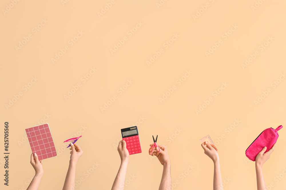 Hands with school supplies on beige background