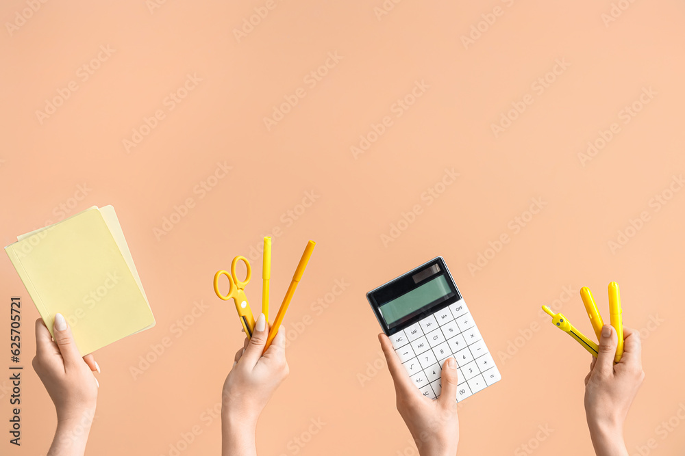 Female hands with school supplies on beige background