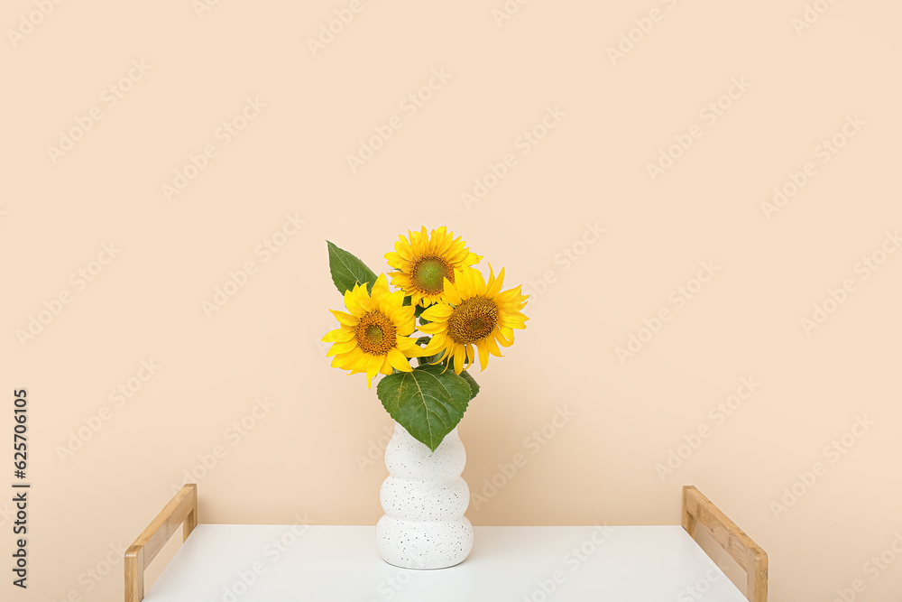 Vase with sunflowers on shelf near beige wall