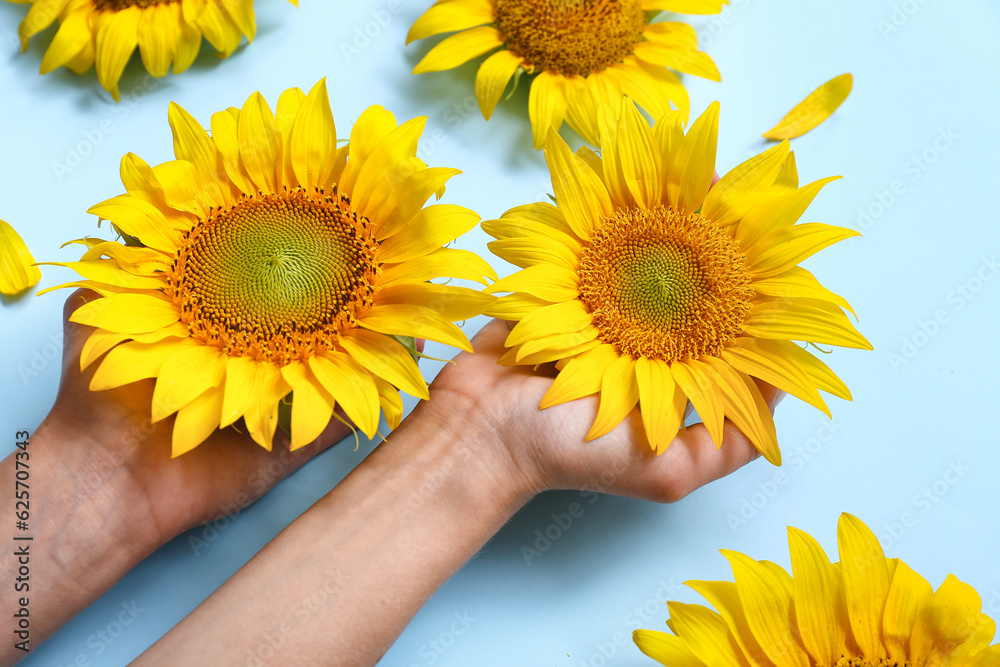 Woman with sunflowers on blue background, closeup