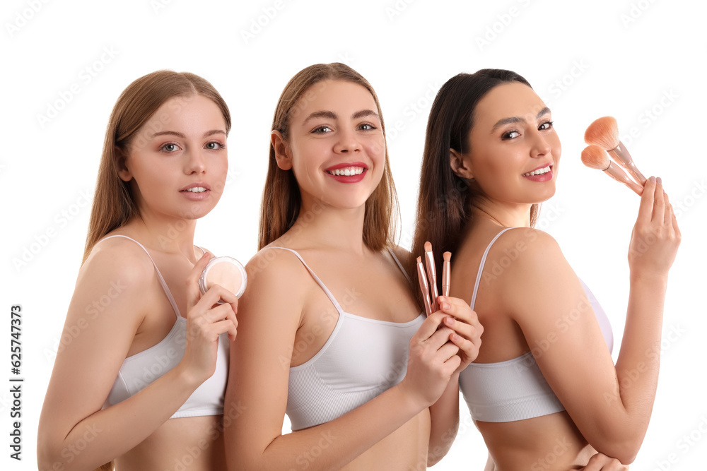 Young women with makeup brushes and powder on white background