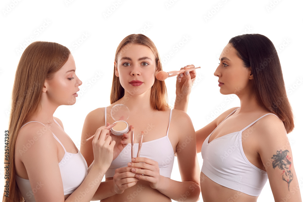 Young women with makeup brushes and powder on white background