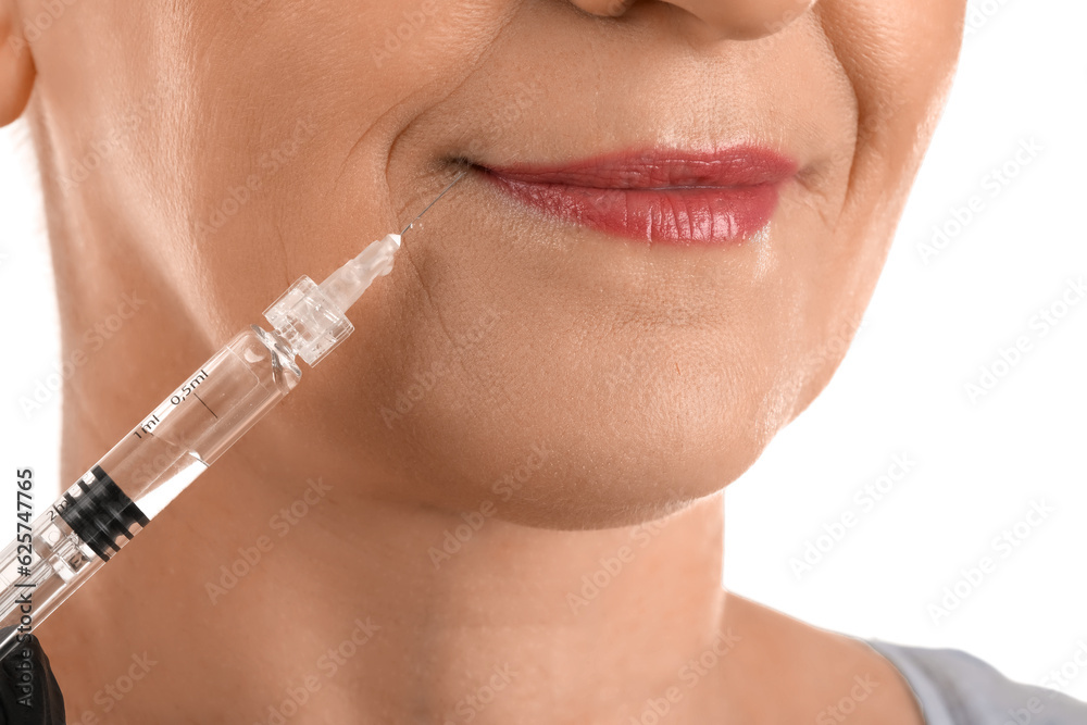 Mature woman receiving filler injection on white background, closeup