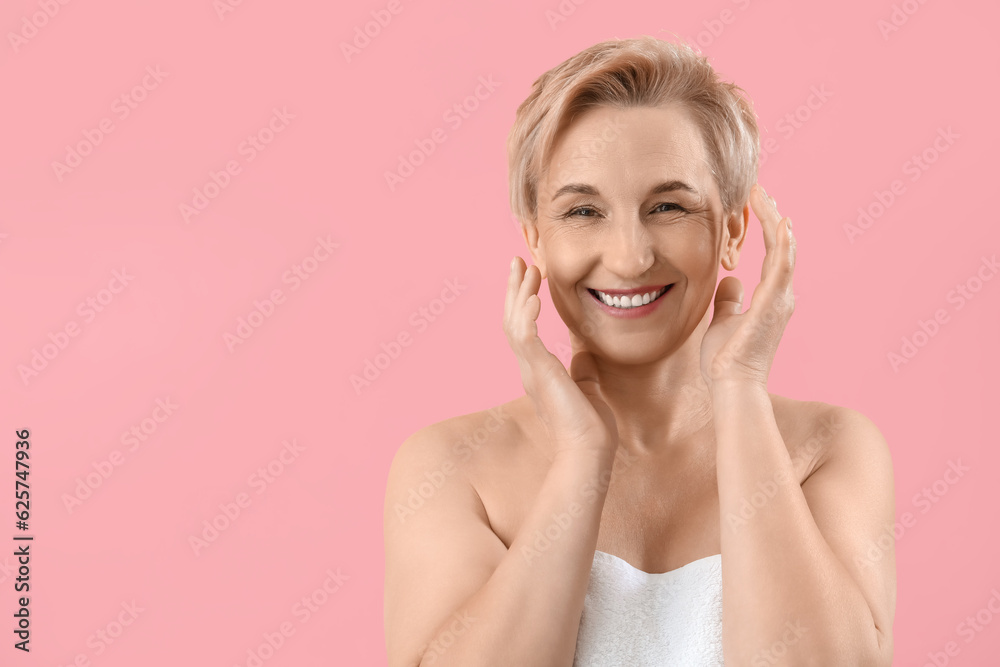 Happy mature woman on pink background, closeup