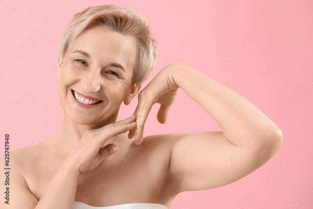 Happy mature woman on pink background, closeup