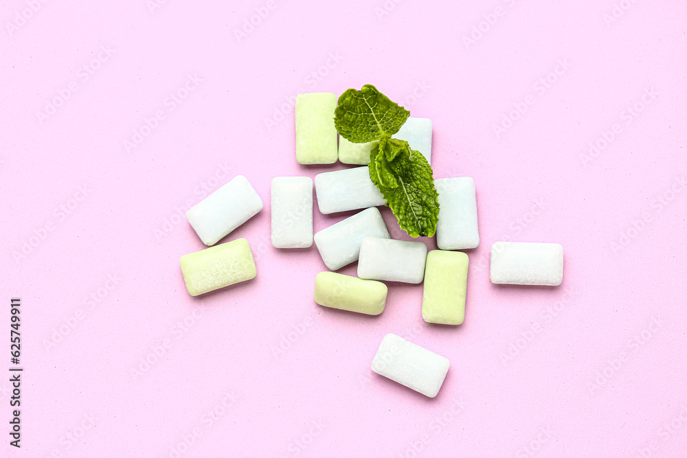 Fresh chewing gums with mint on pink background