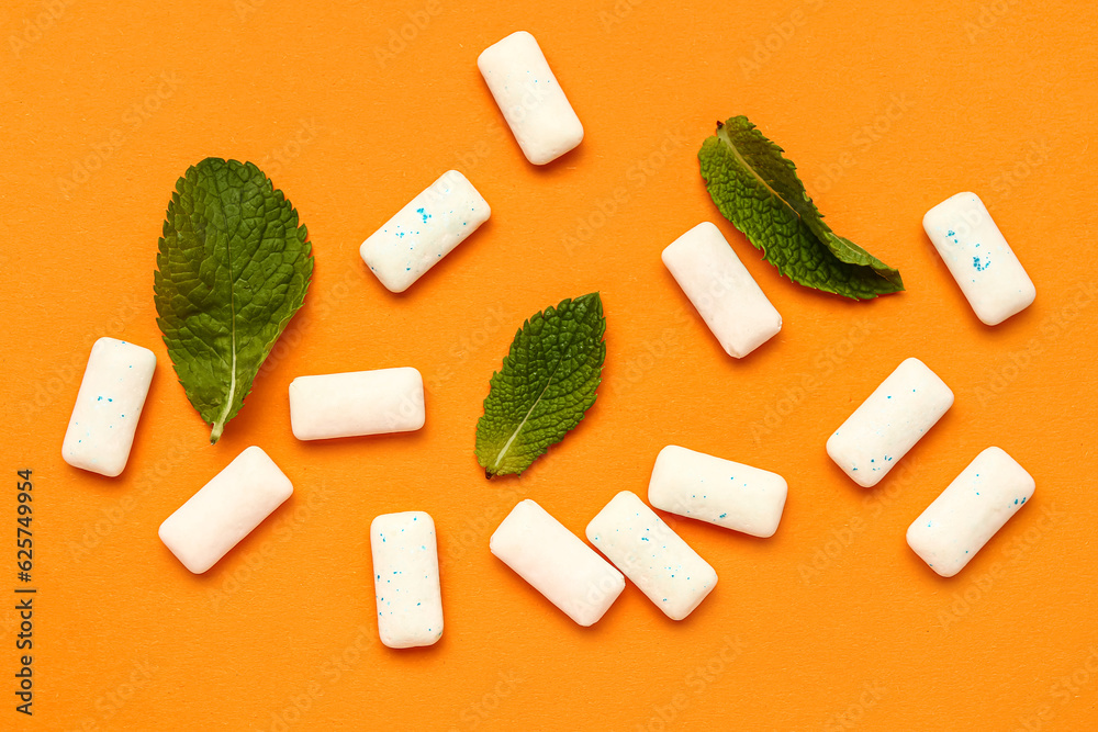 Fresh chewing gums with mint on orange background