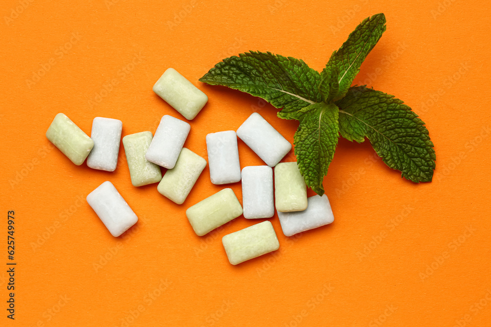 Fresh chewing gums with mint on orange background