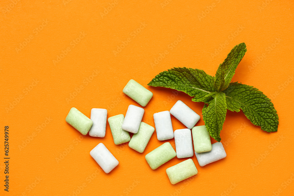 Fresh chewing gums with mint on orange background