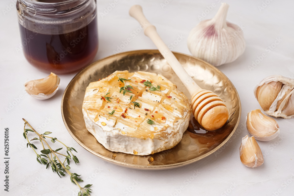 Plate with tasty baked Camembert cheese on grey background