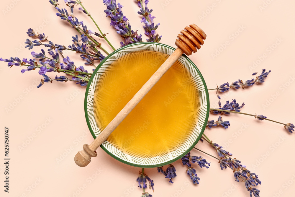 Bowl of sweet lavender honey, dipper and flowers on light background