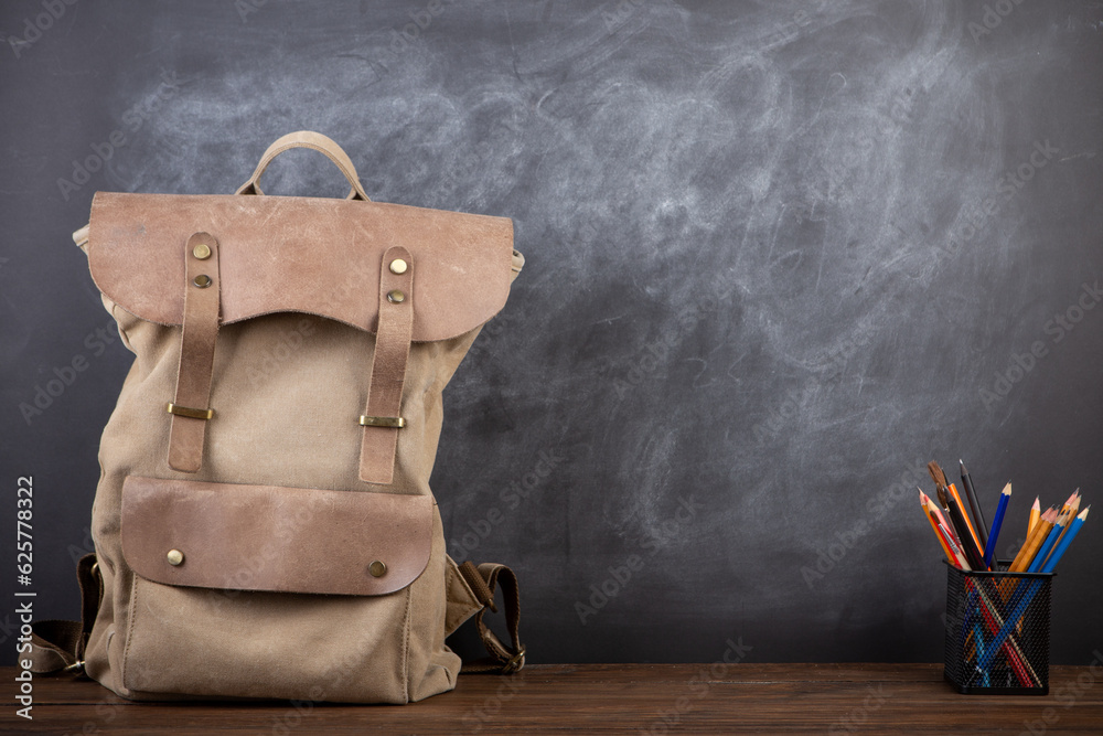 Back to school - books and school backpack on the desk in the auditorium, Education concept.