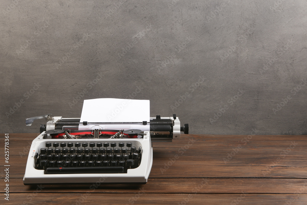 vintage typewriter on the table with blank paper on wooden desk - concept for writing, journalism, b