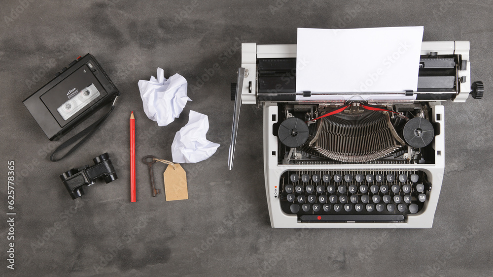 vintage typewriter and tape recorder on the table with blank paper on the desk - concept for writing