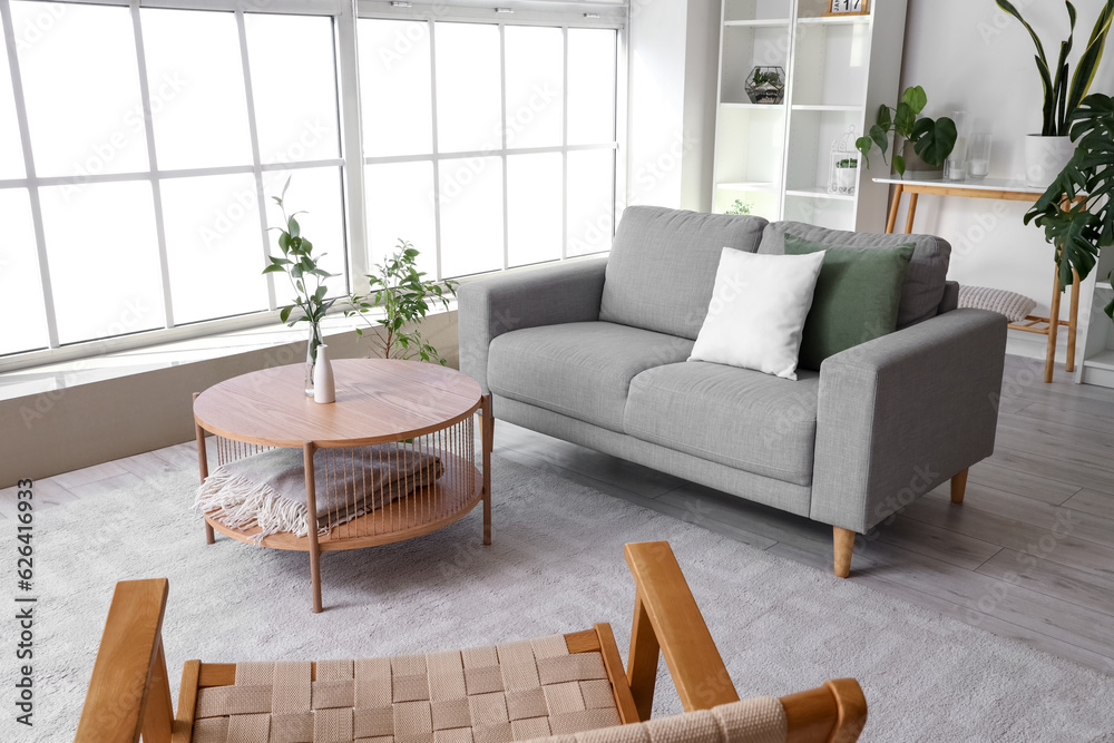 Interior of bright living room with coffee table, cozy sofa and armchair