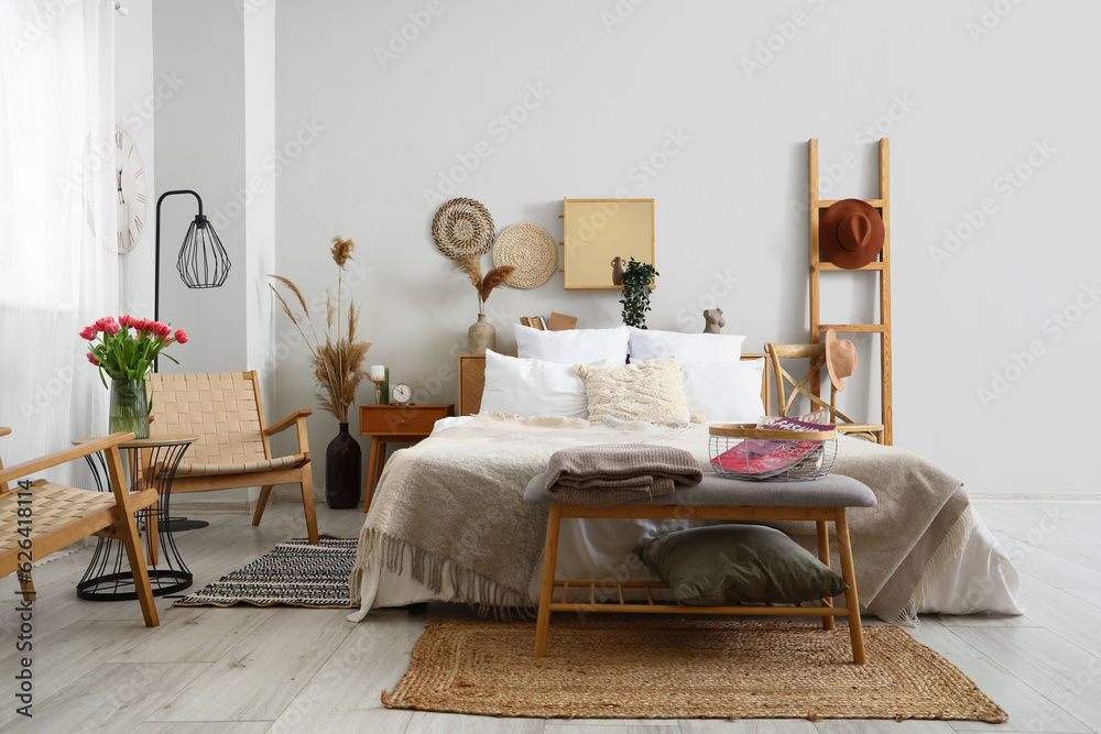 Interior of stylish bedroom with cozy bed and bedside bench