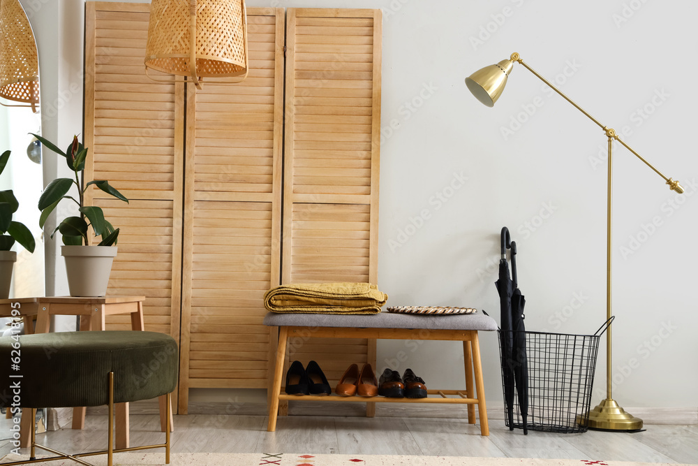 Interior of hallway with bench, folding screen and lamp