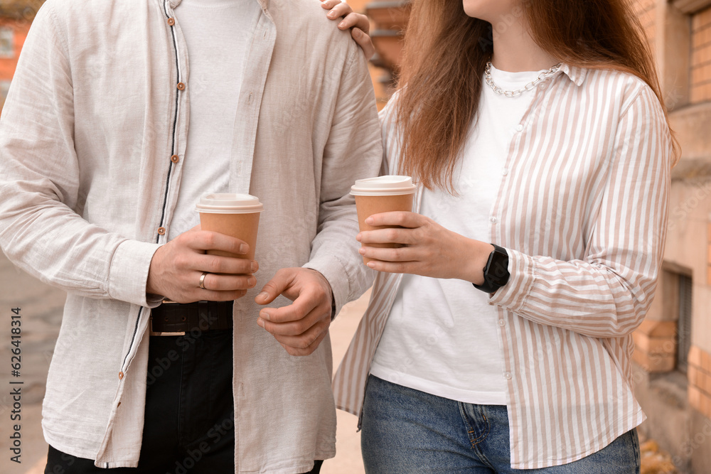 Beautiful loving happy couple drinking coffee and walking in city on spring day