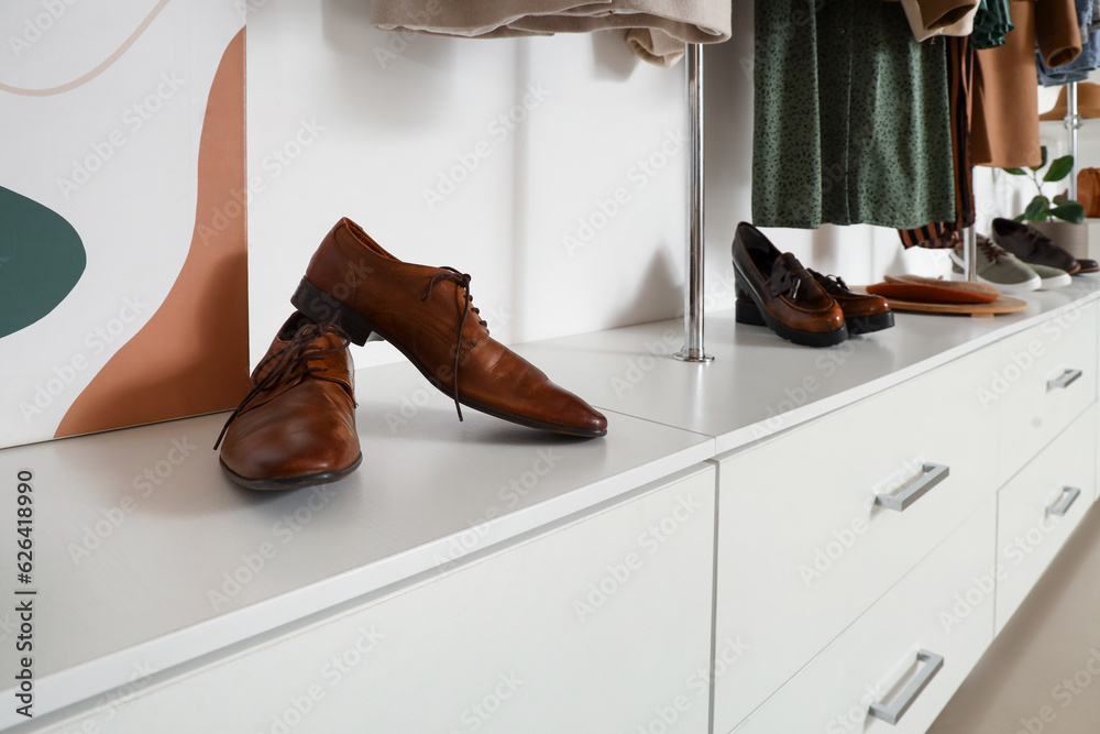 Stylish shoes on shelf in light boutique, closeup