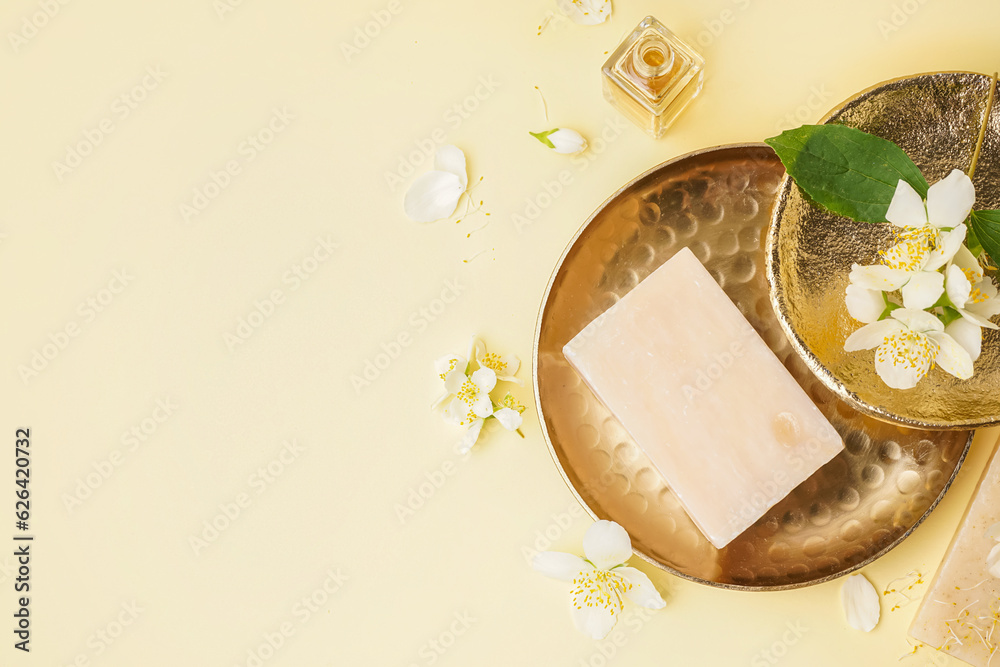 Plates with soap bar and beautiful jasmine flowers on color background