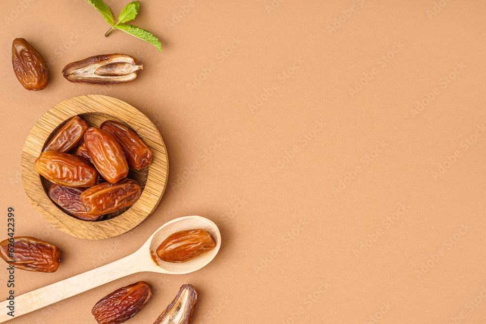 Bowl and spoon with dried dates on brown background