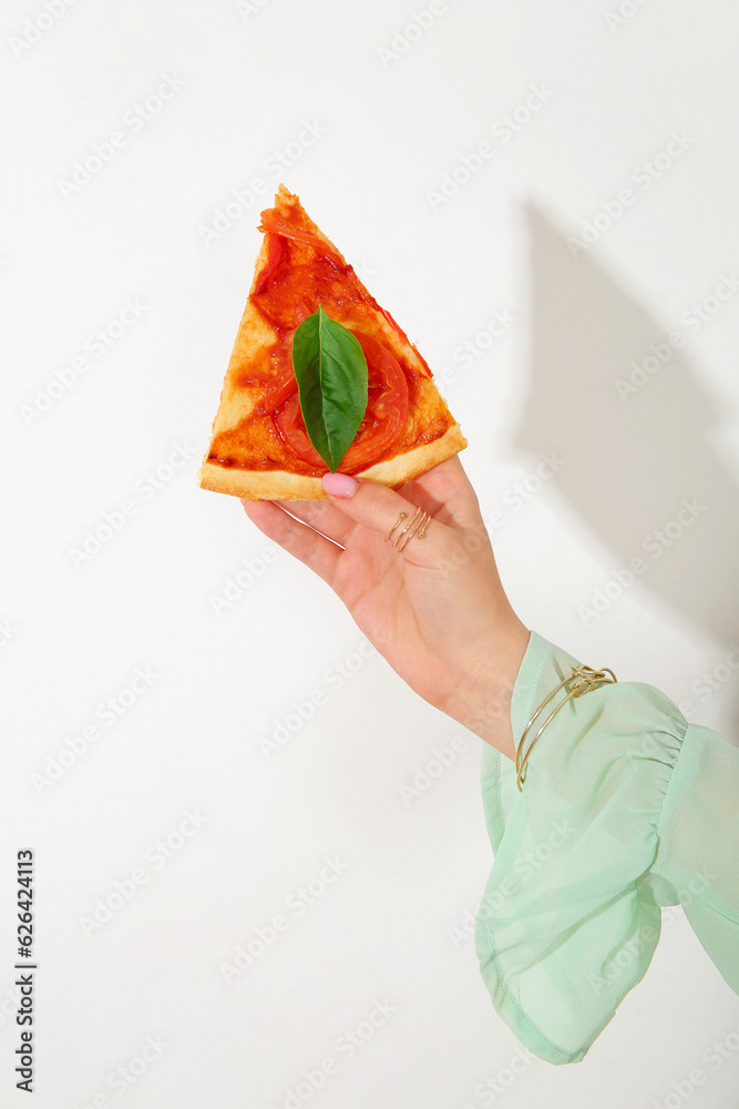 Woman holding slice of tasty pizza on white background