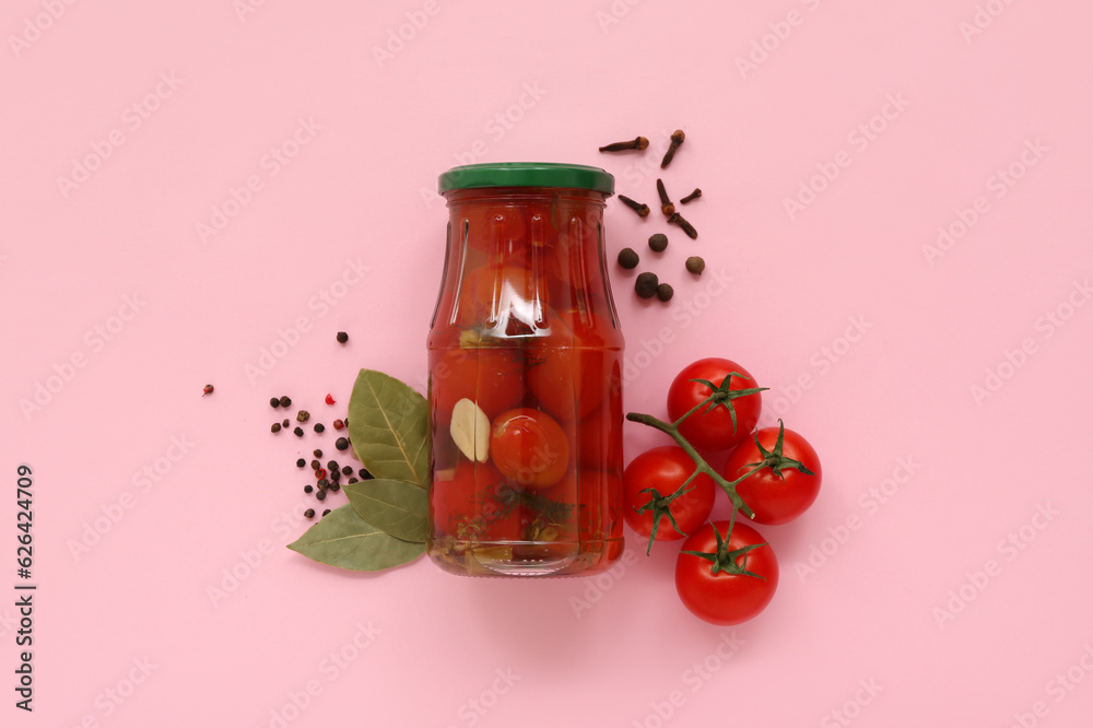 Jar with canned tomatoes and peppercorn on pink background