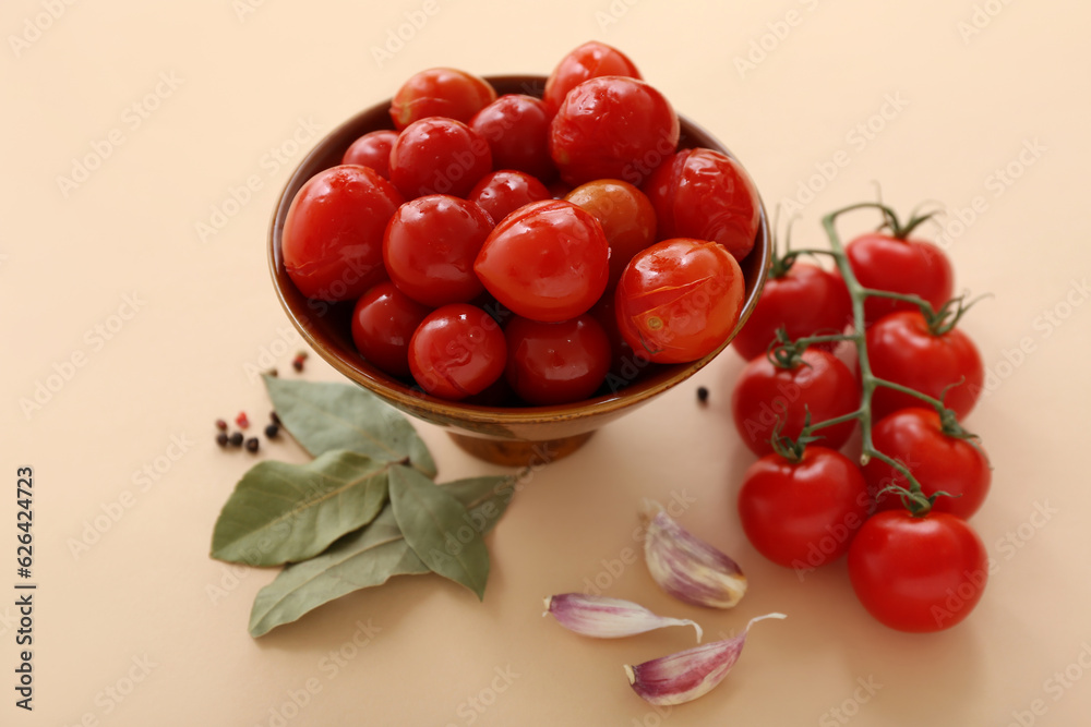 Bowl with canned tomatoes and garlic on beige background