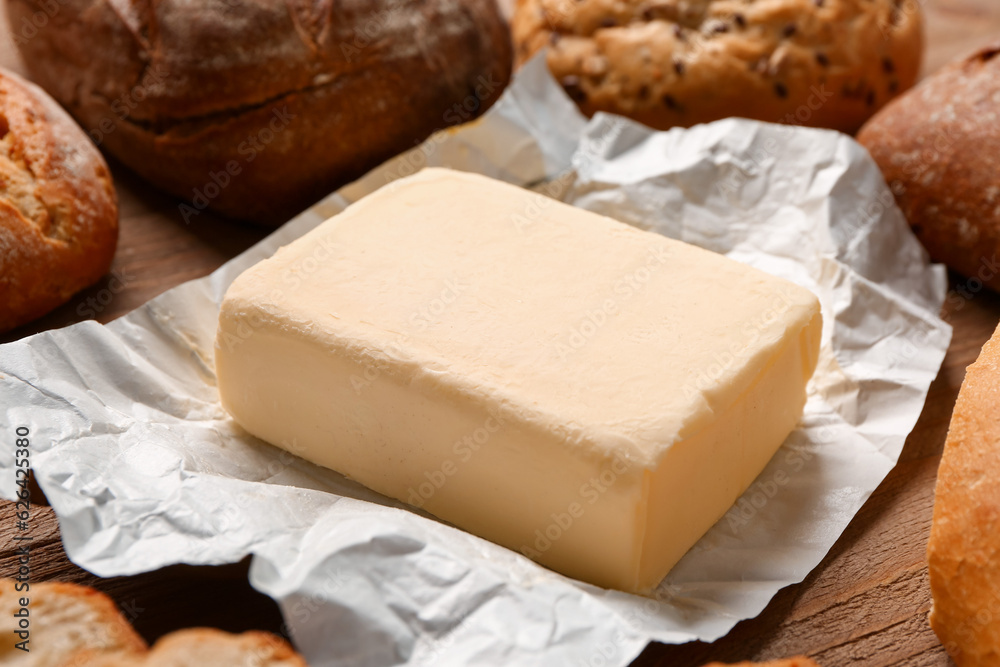 Fresh butter and bread on wooden background