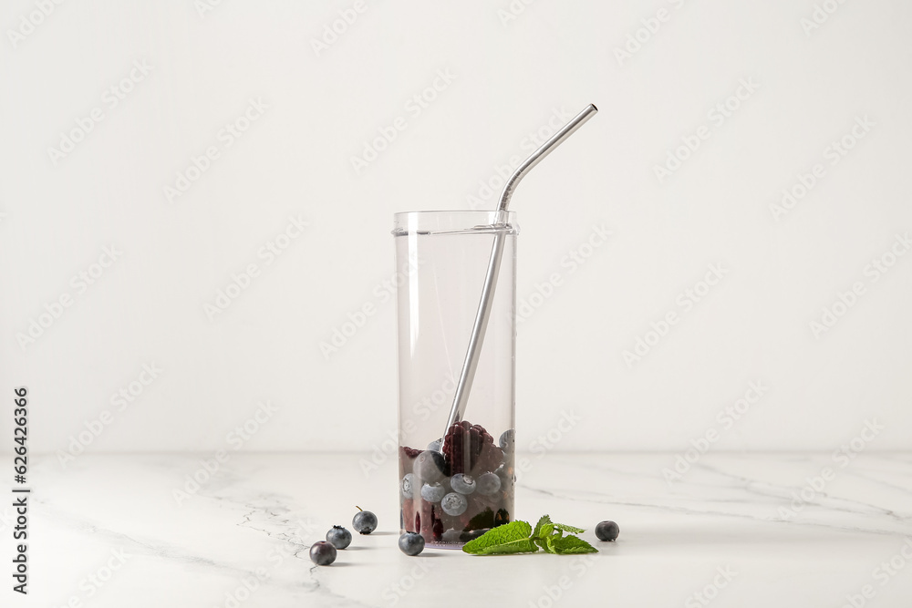 Sports bottle of infused water with blueberries and blackberries on white background