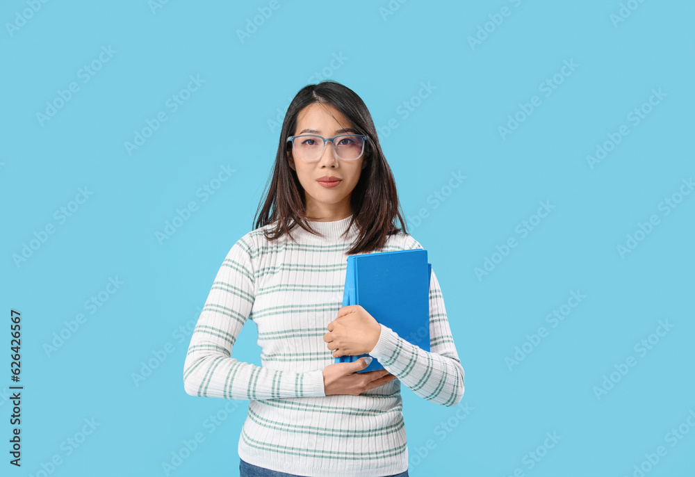 Asian Literature teacher with books on blue background