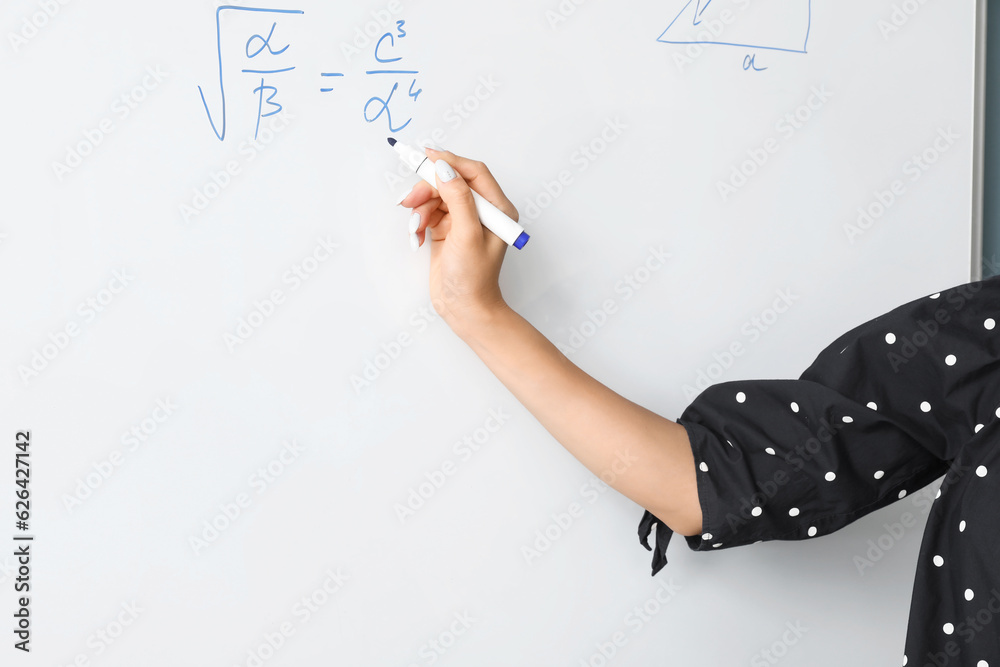 Asian Math teacher near flipboard in classroom, closeup