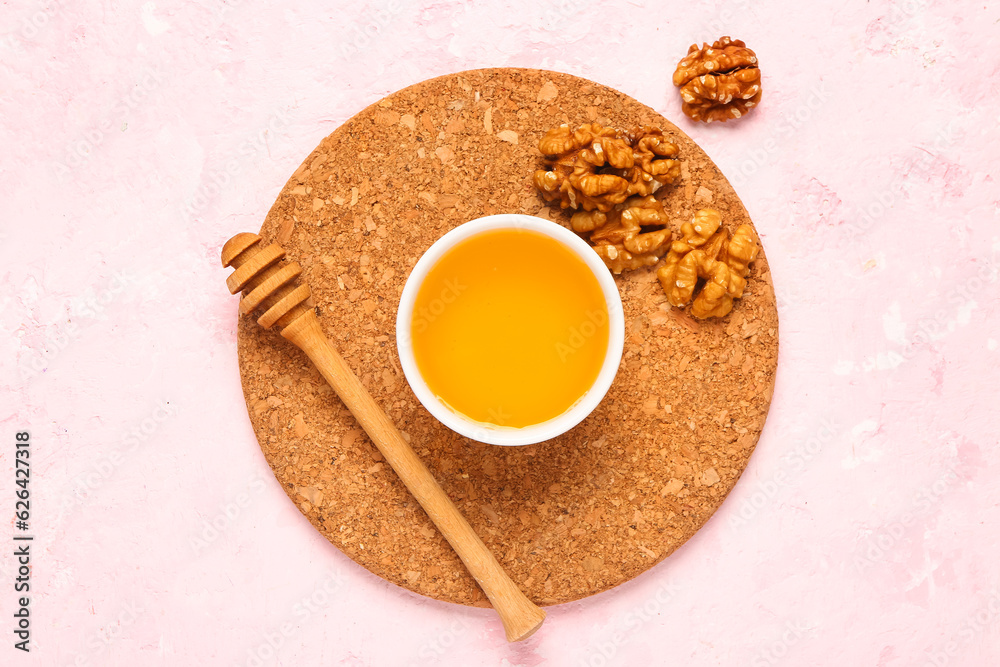 Bowl of sweet honey with walnut and dipper on white background