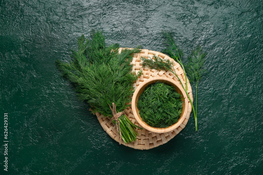 Bowl with fresh dill on green background