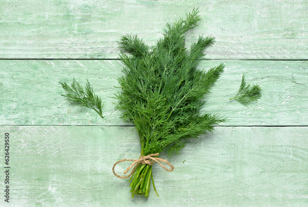 Bunch of fresh dill on green wooden background