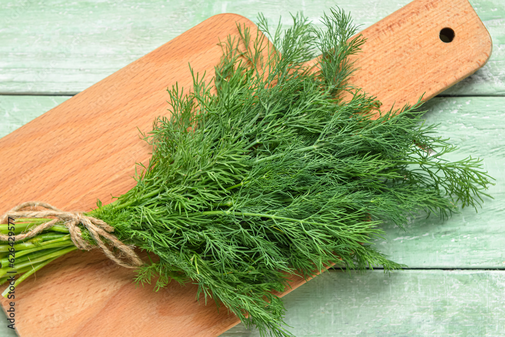 Bunch of fresh dill on green wooden background