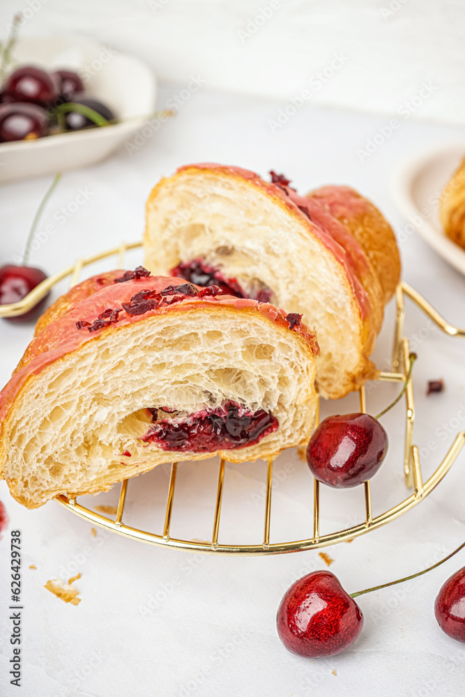 Sweet croissant with jam on light table, closeup