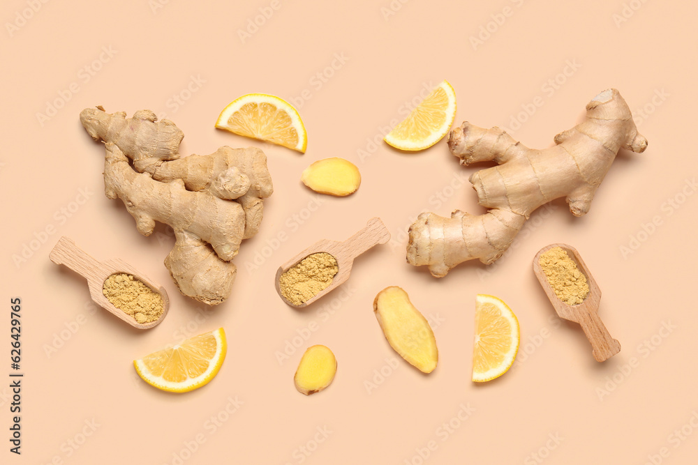 Fresh ginger roots, slices of lemon and wooden scoops with dried powder on orange background