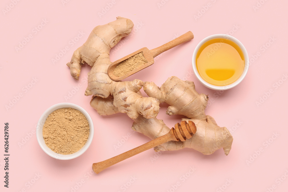 Fresh ginger roots, bowl and wooden scoop with dried powder on pink background