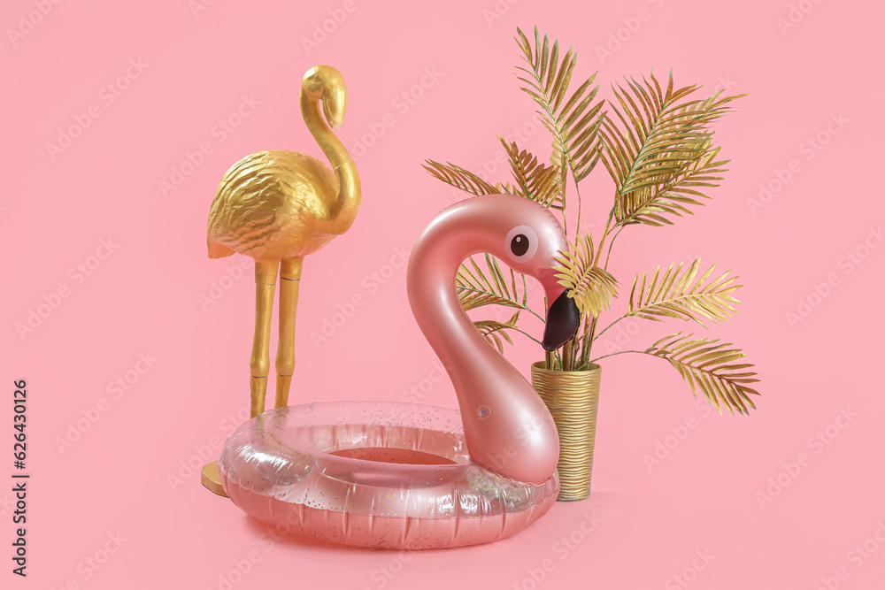 Swim ring in shape of flamingo with decor and palm on pink background