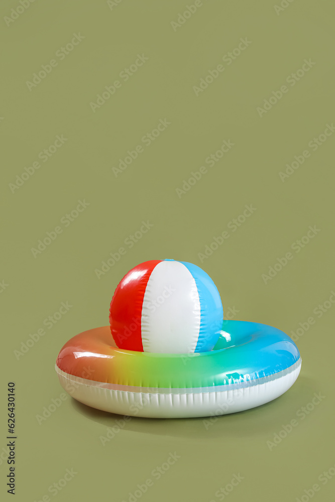 Swim ring with beach ball on green background