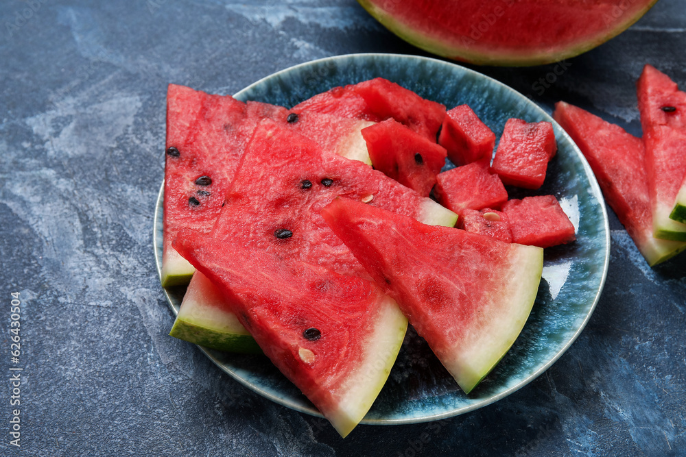 Plate with pieces of ripe watermelon on blue background, closeup