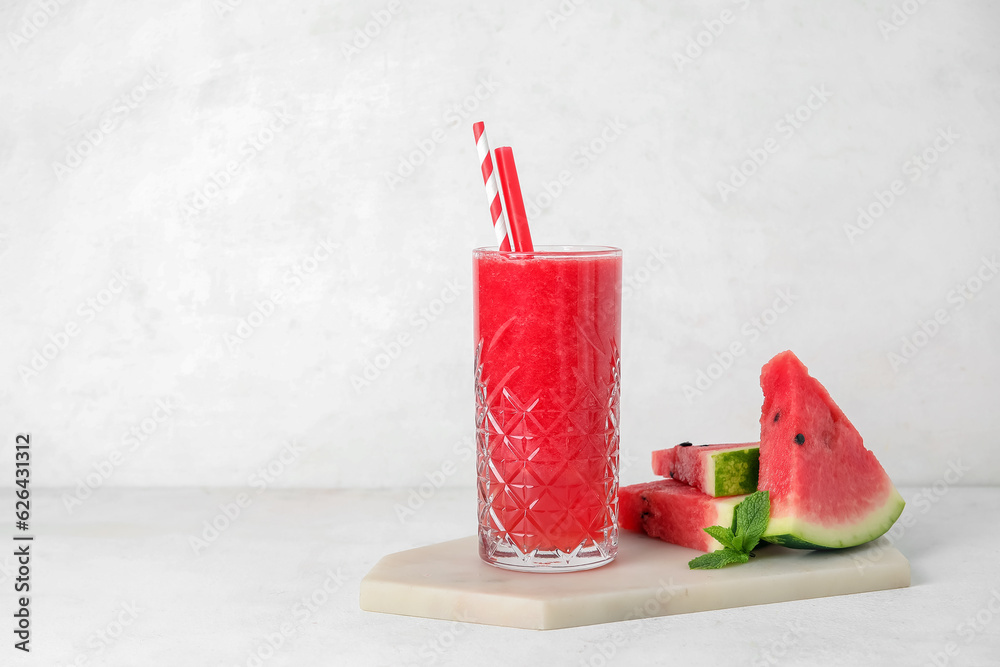 Glass of tasty watermelon juice and mint on white background