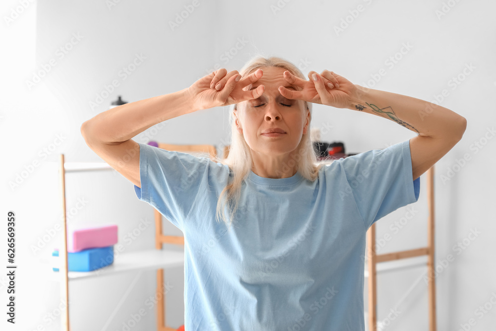 Mature physiotherapist doing face building exercise in rehabilitation center