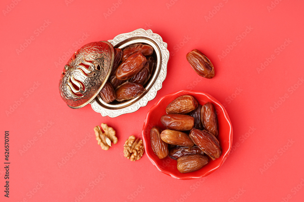 Bowls with dried dates on red background