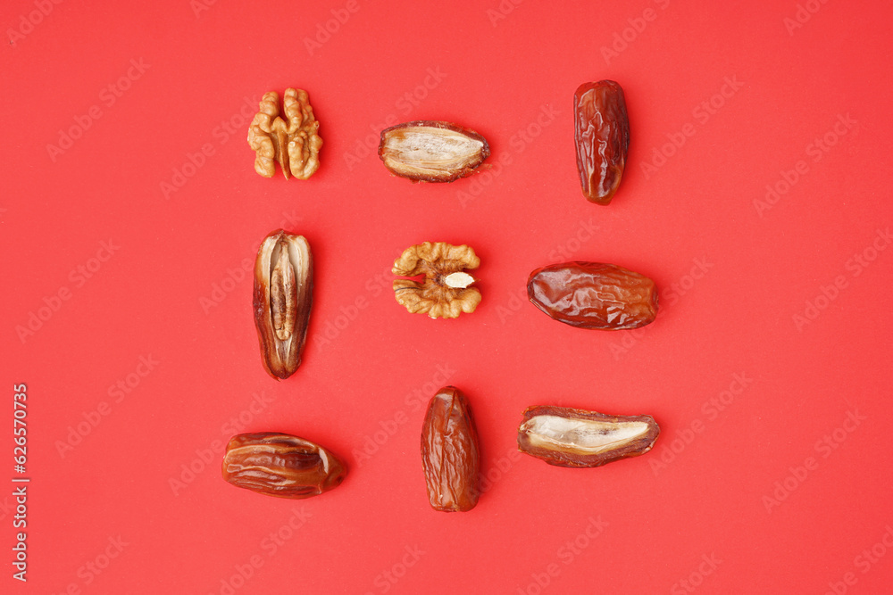 Dried dates and walnuts on red background