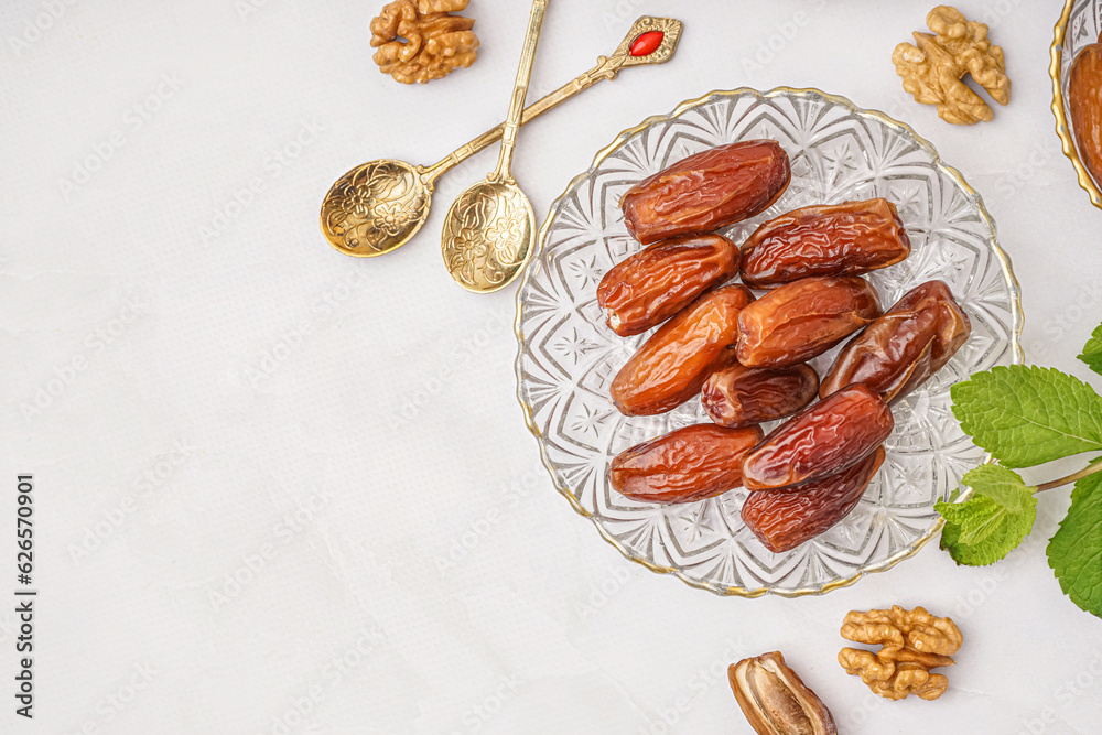 Bowl with dried dates on light background