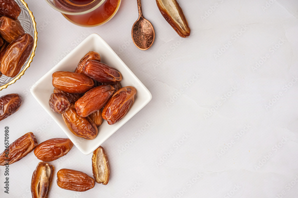 Bowls with dried dates on light background