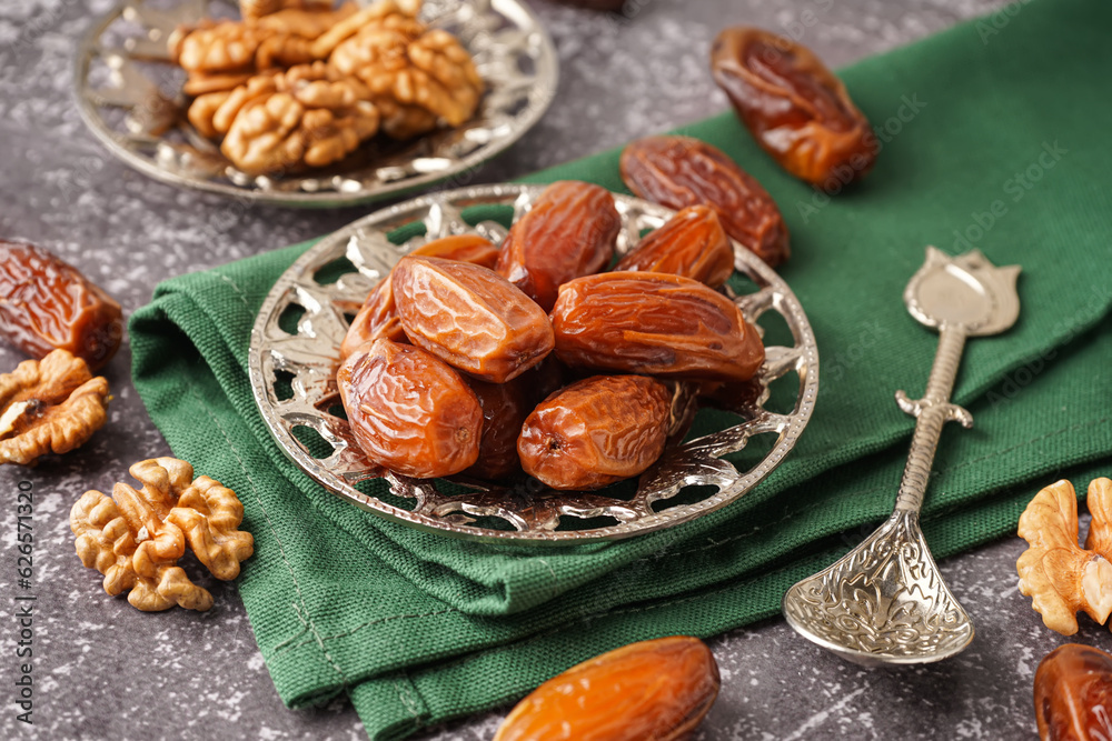 Bowl with dried dates on grey background