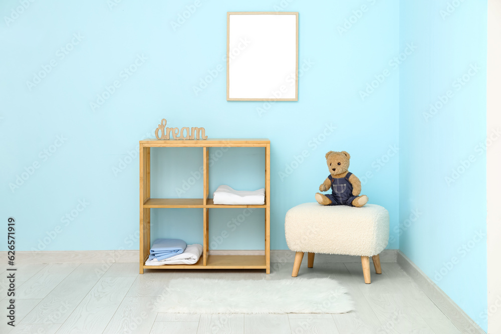 Interior of childrens room with shelving unit, teddy bear and white fur rug